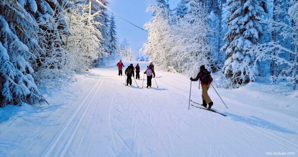 Talvi-illan hämärässä hiihtoladulla hiihtää eri ikäisiä partiolaisia. © Ville Keränen 2026